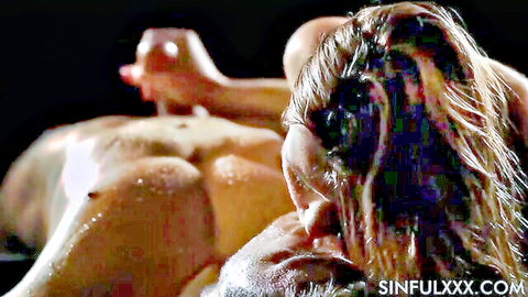 Blonde woman with wet hair giving sensuous slow handjob to muscular man