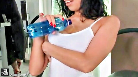 Busty brunette gym babe in tight white tank top drinks water spilling on huge tits cleavage