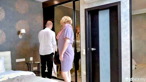 Sensual blonde granny with glasses in purple dress enjoys blowjob with man