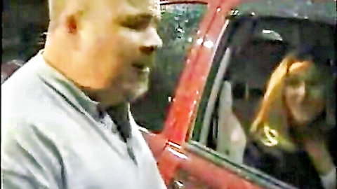 Husband leans in as wife watches in cuckold car scene