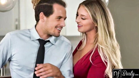 Busty blonde Kayley Gunner smiling intimately with man in kitchen red dress