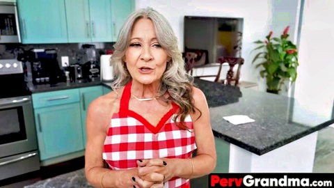 Leilani Lei as gray-haired Asian stepgrandma in red checkered apron, smiling in kitchen
