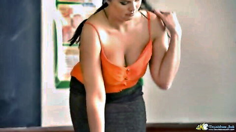 Teacher in orange top with deep cleavage and big natural breasts
