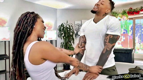 Ebony babe in white tank gropes tattooed black man's crotch bulge as he grins down
