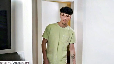 Curly-haired tattooed guy in green t-shirt stands in doorway
