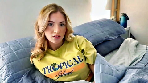 Sexy blonde freckled babe in tight Tropical Island t-shirt teasing big tits on bed