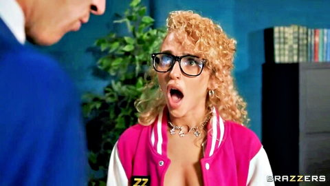 Blonde cheerleader with glasses opens pink varsity jacket flashing tits at suited man in classroom