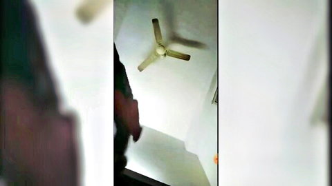 Blurry Indian bhabhi in green top with man in bedroom under fan