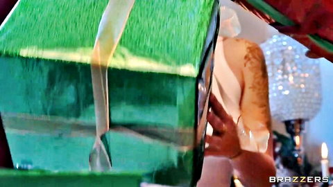 Curvy woman emerging nude from Christmas gift box, festive Brazzers holiday tease