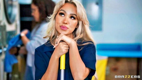 Blonde bombshell in sexy cleaner uniform poses with mop seductively