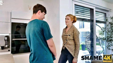 Mature Angelica in cardigan chats with younger man in kitchen tease