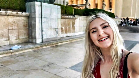 Smiling young blonde showing medium tits cleavage in tight red top outdoor selfie