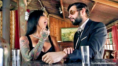Lily Lane in sultry BDSM chat with Tommy Pistol at bar, Kink studio