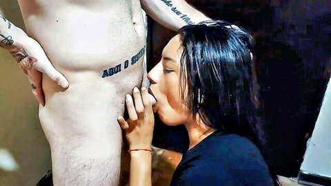 Brunette Indian woman kneeling to kiss tattooed boyfriend's nude crotch
