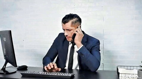 Rocky Vallarta in blue suit on intense phone call at desk
