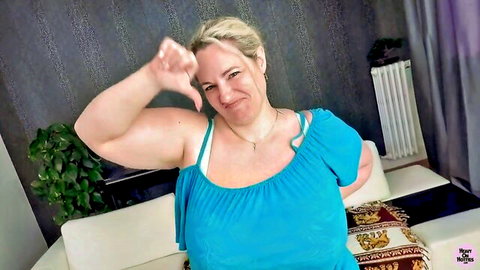 Sophia Lola BBW blonde teasing with finger to lips in blue off-shoulder top