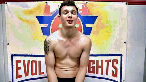 Josh Rivers topless in Evolved Fights, smirking wrestler vs Avery Jane