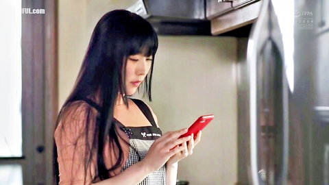Tina Nanami in apron and dress, checking red phone in kitchen, JAV softcore