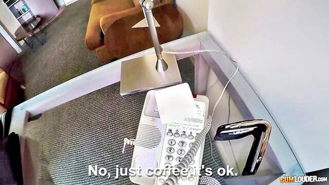Hotel room desk with white phone and lamp, 'No just coffee's ok' text overlay on Pornhub preview
