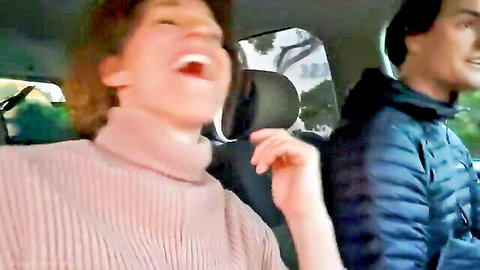 Stepmom and stepson laughing intimately in car seat