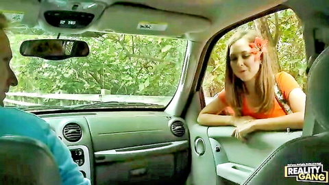 Cute teen with flower in hair hitches ride in car, leaning in window
