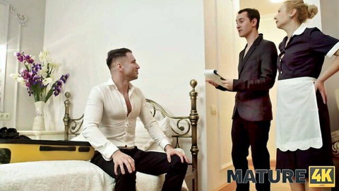Mature blonde maid in uniform teases Oliver Trunk and friend in hotel room threesome