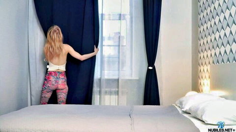 Blonde babe in tight patterned leggings pulls back bedroom curtains showing small ass