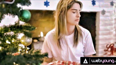 Blonde Kristen Scott in white t-shirt by Christmas tree, lesbian scene with Kenna James