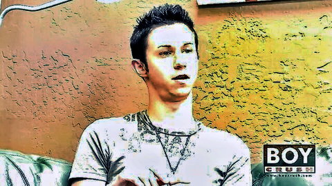 Cute spiky-haired twink boy in gray t-shirt posing seductively against yellow wall