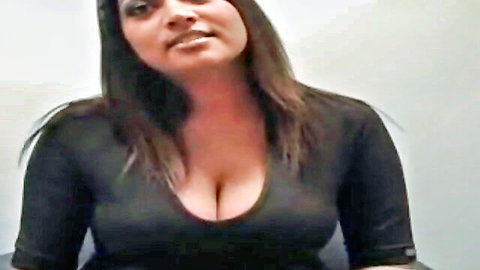 Sexy Indian webcam babe with massive natural tits in deep cleavage black top smiling seductively
