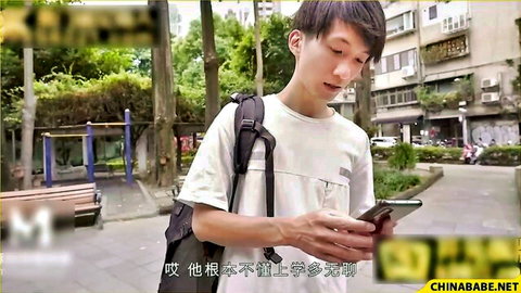 Young Asian man in white shirt checking phone outdoors on urban street