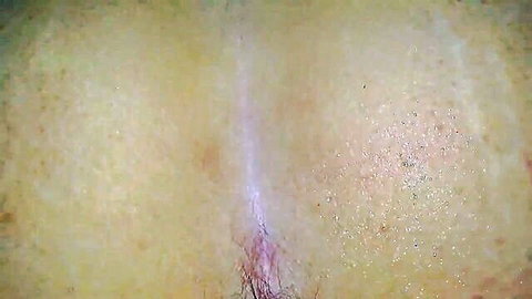 Close-up of mature woman's spread ass showing hairy gaping anus