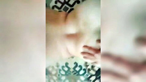 Blurry closeup of ecstatic Turkish woman moaning with eyes closed wearing patterned top