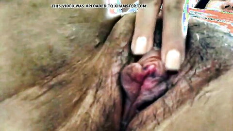 Southeast Asian woman spreads her wet pink pussy lips wide open with fingers in closeup solo tease