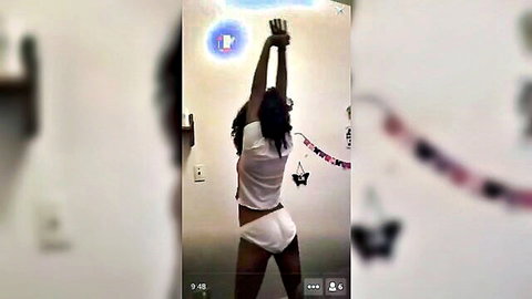 Brunette athletic MILF raises arms in tight white tank top and panties showing round ass