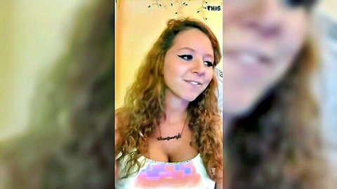 Curly blonde college girl smiling with cleavage in colorful top