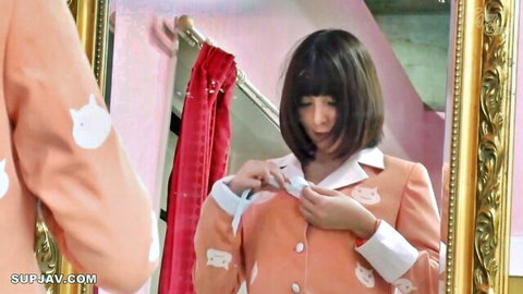 Japanese brunette in sexy orange cat print suit adjusting jacket showing cleavage in mirror