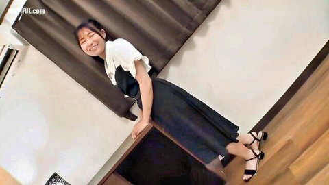 Cute Japanese girl in white blouse and black skirt smiling sideways teasingly