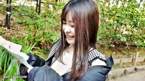 Young Asian babe with big tits teases deep cleavage in open jacket outdoors smiling