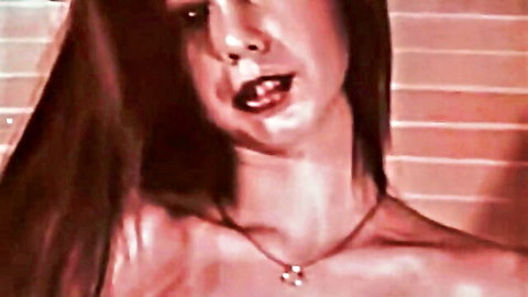 Classic porn brunette with long hair, red lips, ecstatic face and cleavage close-up
