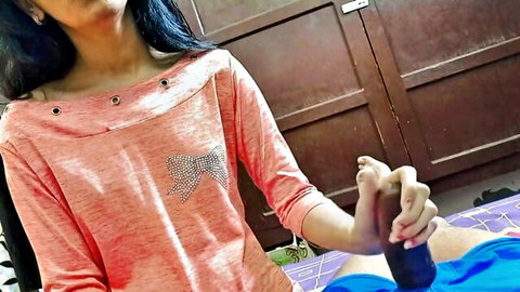 Desi MILF in pink top giving handjob to man on bed POV