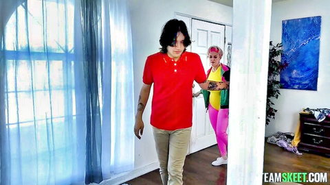 Sporty MILF with pink hair in colorful leotard and man in red shirt entering room for kinky group sex