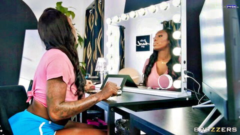 Curvy tattooed ebony babe with huge tits in tight pink crop top and blue shorts at vanity mirror