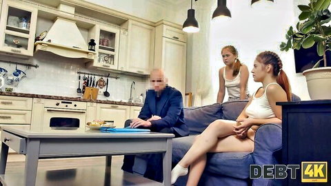 Bald man in suit gropes thigh of sexy redhead Russian teen on couch while blonde watches in kitchen