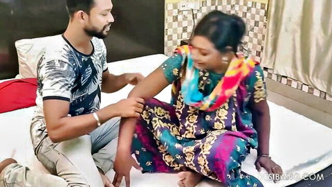 Desi couple in intimate touch, woman in colorful saree, man kneeling beside her