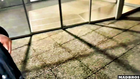 Man's leg in dark pants extended on tiled floor near glass doors with shadows.