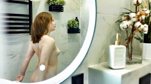 Nude redhead beauty posing in bathroom mirror reflection