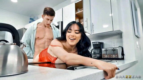 Muscular stud grinds behind smiling Latina bent over kitchen counter, open apron exposing her tits