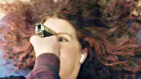 Redhead woman in tense gunpoint confrontation scene