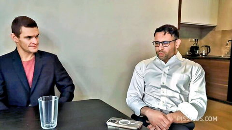 Two suited men sitting at kitchen table discussing before piss play on PISSLOVERS